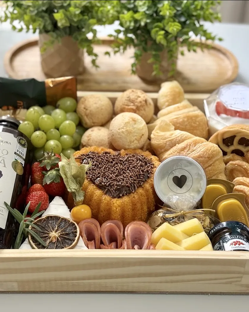 Bandeja de café da manhã com bolo em formato de coração, pães e frutas